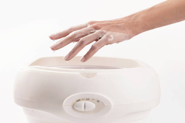 woman in nail salon having paraffin bath"n - kerosene imagens e fotografias de stock