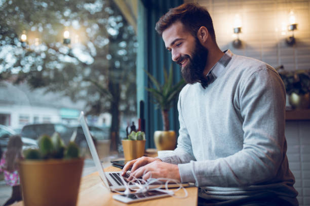 istock Trendy blogger typing on laptop in cafe. 894420186