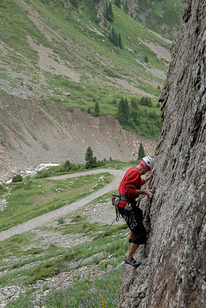climber climbing a cliff stock photo