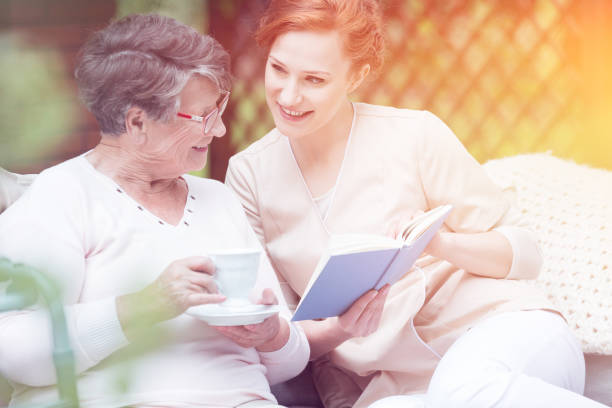 istock Pretty caregiver and elderly woman 894429214