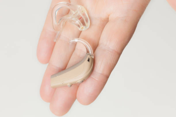 istock senior person holding hearing aid closeup 894429796