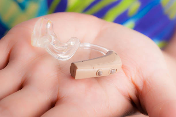 istock senior person holding hearing aid closeup 894430266