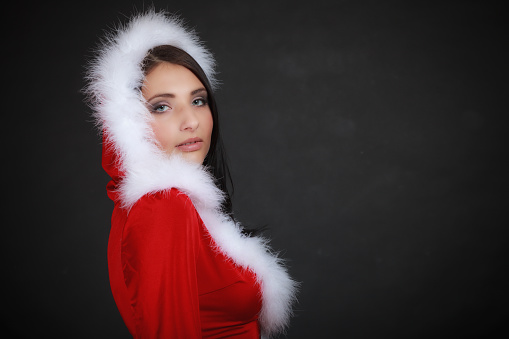 Beautiful sexy woman wearing santa clause costume clothes on black background
