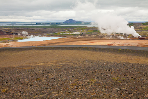 A panoramic view from Myvatn Lookout of Myvatn geothermal power stations with Myvatn lake in the distance.