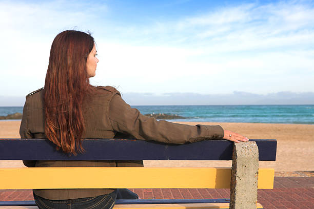 istock Woman on bench next to sea 89443778