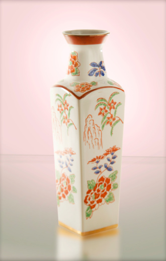 Antique bone china vase with porcelain flowers on a white background.