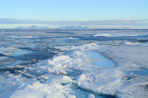 The still waters of the ocean surrounding Svalbard, Norway under beautiful altocumulus clouds