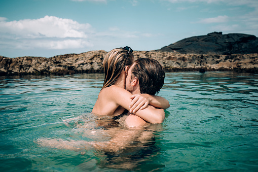 Young couple floating in the Champagne Pools on Fraser Island, Australia.