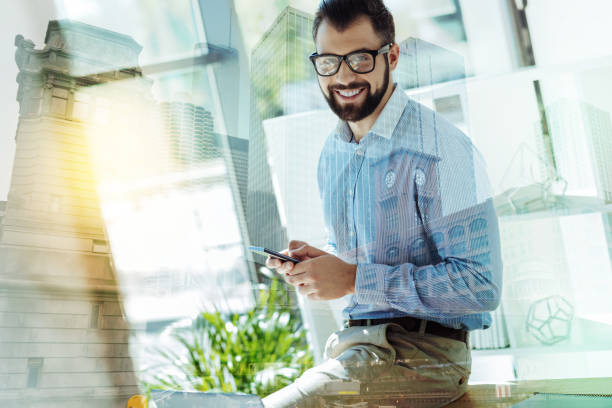 istock Pleasant joyful man using the smartphone and looking straight 894447352