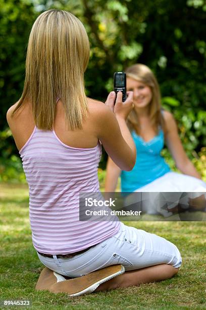 Photo libre de droit de Deux Filles En Dehors À Prendre Des Photos À Laide Dun Appareil Photo De Téléphone banque d'images et plus d'images libres de droit de Adolescent