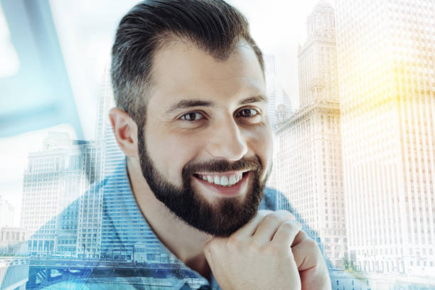 istock Joyful confident man holding hands near beard and smiling 894458040