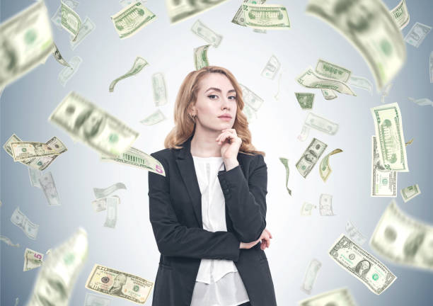 istock Pensive red haired businesswoman, dollar rain 894460300