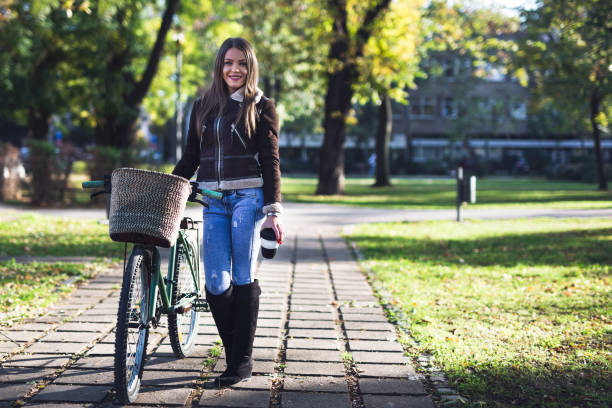 istock Young happy lady with bicycle in public park 894461652