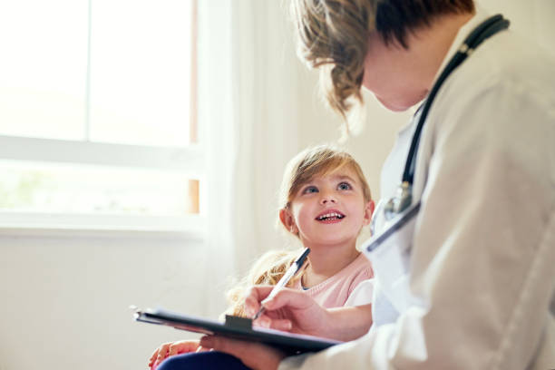 Feeling fully at ease with doc Shot of a doctor having a consultation with a little girl in her consulting room pediatrician stock pictures, royalty-free photos & images