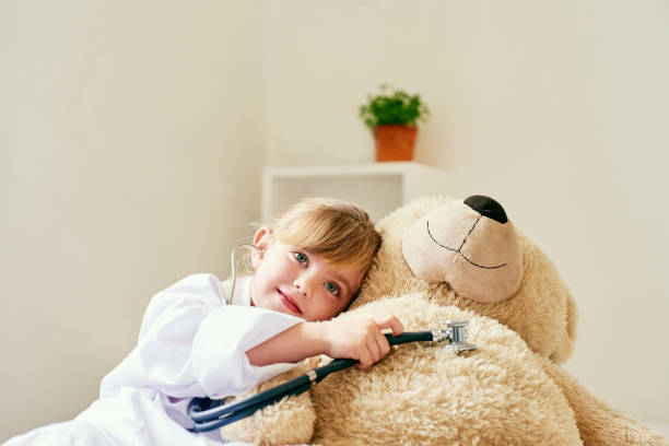 Now that's a happy sounding heart Shot of an adorable little girl dressed up as a doctor and examining a teddy bear with a stethoscope girl patient stock pictures, royalty-free photos & images