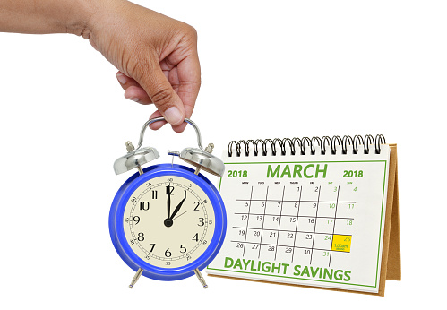 Daylight Savings Time March 2018 Calendar Hand holding 1 o'clock alarm clock white background