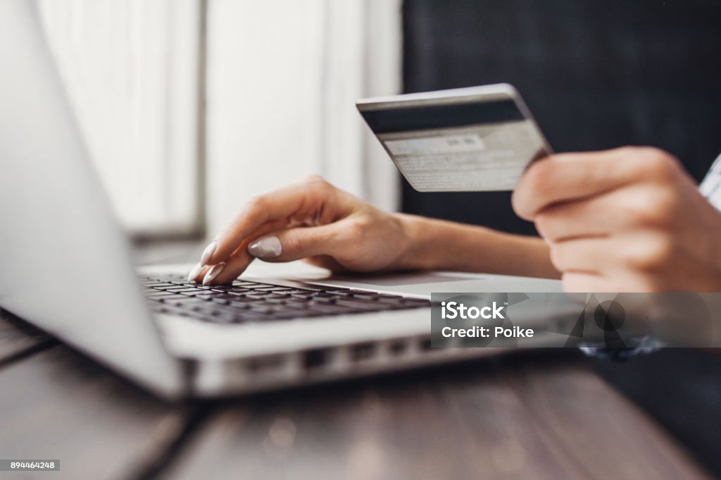Woman is shopping online with laptop computer and credit card Female hands typing on laptop. Online shopping concept Online Shopping Stock Photo