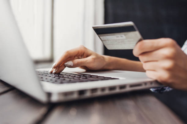 женщина делает покупки в интернете с ноутбуком и кредитной картой - credit card women laptop electronic banking стоковые фото и изображения