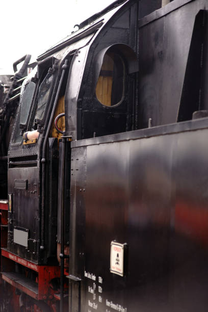 The side view and cabin of an old steam locomotive with coal for heating the steam boiler.