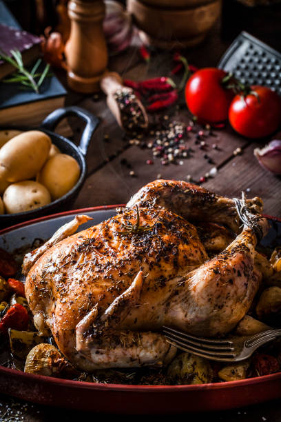 istock Baked chicken with vegetables on rustic wooden table 894476620