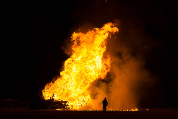istock Man silhouette gazing at a large bonfire, Bafana celebration, Italy 894481008