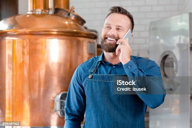 Master Brewer Talking On Mobile Phone In Brewery Stock Photo - Download Image Now - Owner, Small Business, Talking