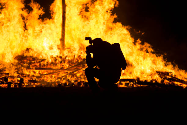 istock Photographer silhouette squatting by the bonfire 894484176