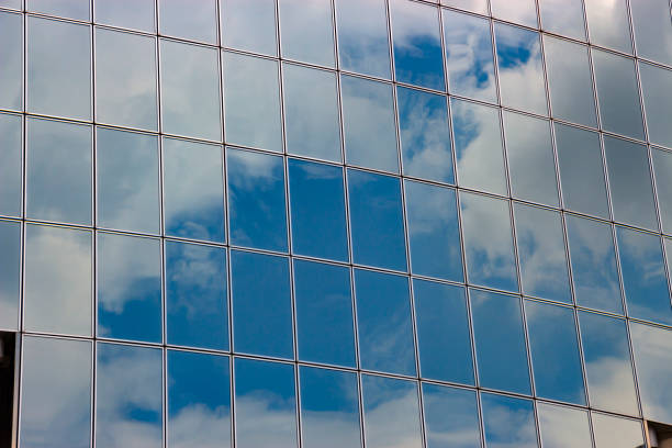 nuvens refletidas nas janelas do edifício de escritório moderna - window reflection - fotografias e filmes do acervo