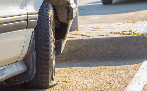 beschädigte platten reifen ein altes auto auf der straße mit selektiven fokus - 6729 stock-fotos und bilder