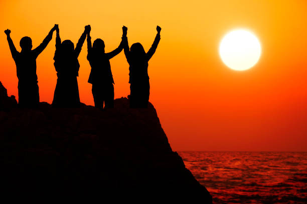 istock Silhouette four business people make high hands when business success ,teamwork concept 894524550