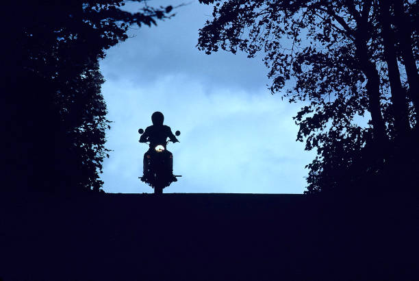 Silhouette of motorcyclist on vintage motorcycle.