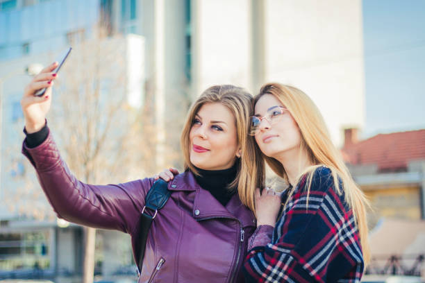 istock Friends making selfie. Two beautiful young women making selfie 894536070