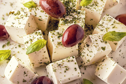 Greek cheese feta with oregano and olives, selective focus.