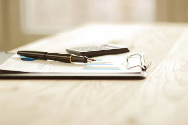 istock pen, calculator and financial graph on a workplace 894560068