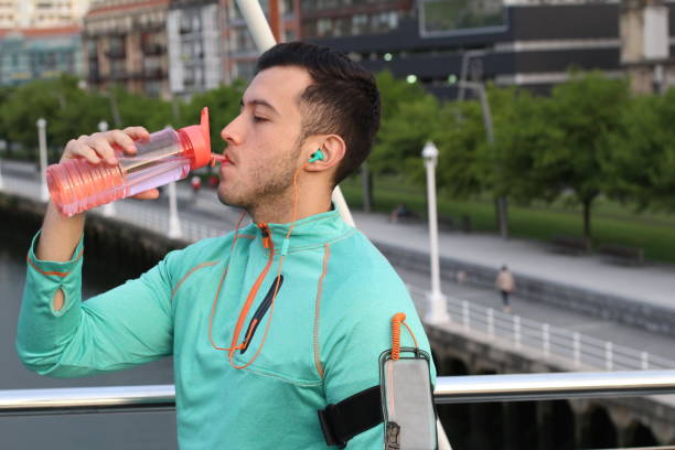 asiática masculina bebendo água ao ar livre com copyspace - water bottle sports and fitness selective focus sport - fotografias e filmes do acervo