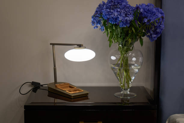 istock Lamp, nightstand and flowers 894587216