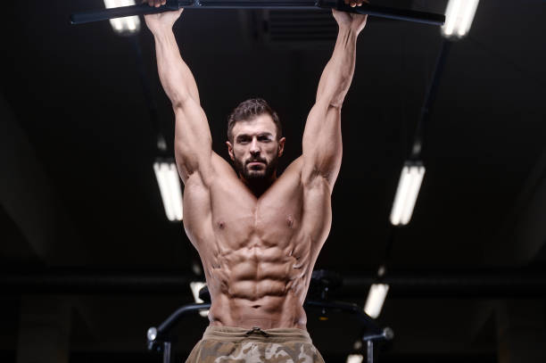 istock sexy strong bodybuilder athletic men pumping up muscles with dumbbells 894592992