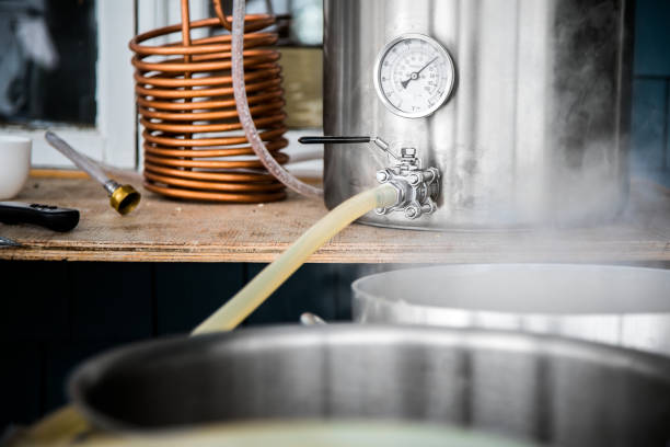 istock Home Brewing Kit and Pouring Craft Beer Wort into the Boil Kettle. 894596604