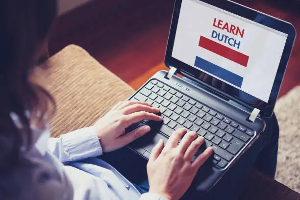 Photo of Female learning dutch at home with a laptop.