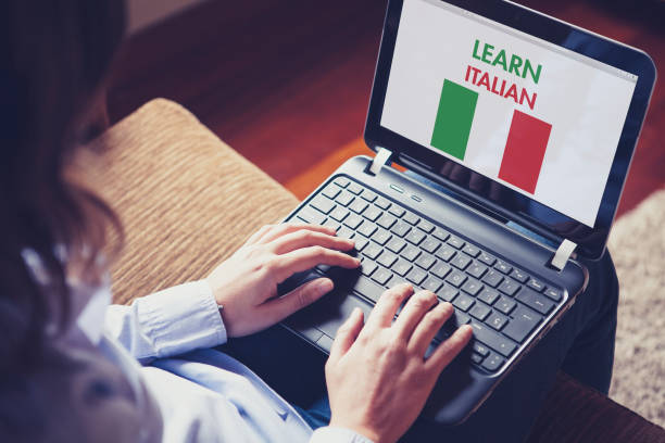 hembra de aprender italiano en casa con un ordenador portátil. - italiano idioma fotografías e imágenes de stock