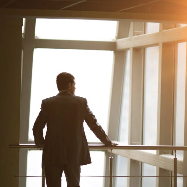 istock Businessman looking out the window thinking about business ideas 894603096
