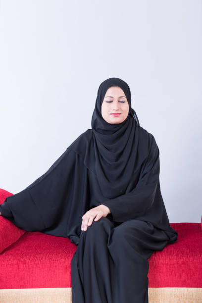 istock Arab woman sitting on sofa chair 894605908