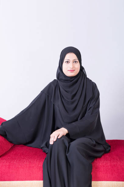 istock Arab woman sitting on sofa chair 894605922