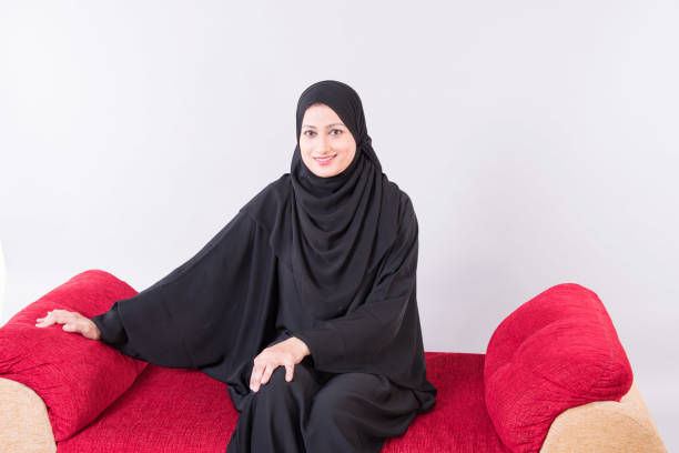 istock Arab woman sitting on sofa chair 894606024