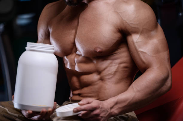 istock sexy strong bodybuilder athletic men pumping up muscles with dumbbells 894606104