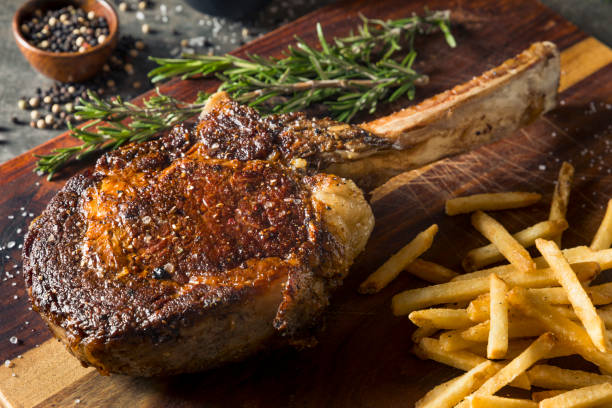 grass fed tomahawk steaks gekocht - kotelett stock-fotos und bilder