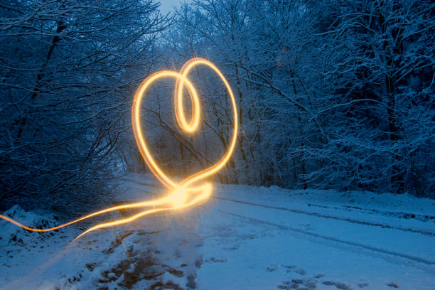 istock Light effect in the form of a heart. Winter forest at the night. 894614822
