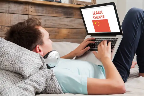 Photo of Man learning chinese at home.