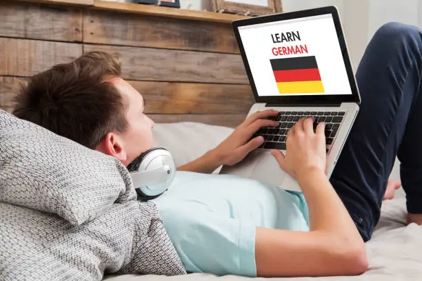 Photo of Man learning german at home.