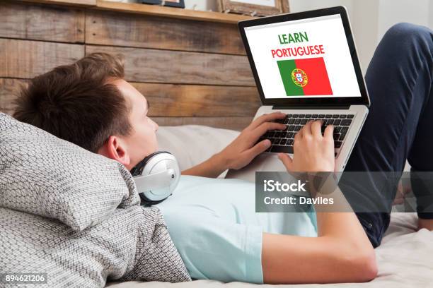 Man Learning Portuguese At Home Stock Photo - Download Image Now - Adult, Bed - Furniture, Bedroom